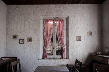Terk edilmiş büyük bir evde kırmızı perdeli bir pencere. Yüksek kalite fotoğraf