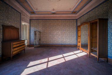 Büyük terk edilmiş bir evde mobilyaları ve rafları olan büyük bir oturma odası. Yüksek kalite fotoğraf