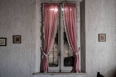 Terk edilmiş büyük bir evde kırmızı perdeli bir pencere. Yüksek kalite fotoğraf