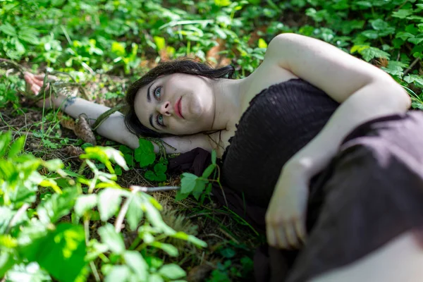 黑发女孩躺在常春藤的草地上 身无分文的棕色连衣裙 高质量的照片 — 图库照片