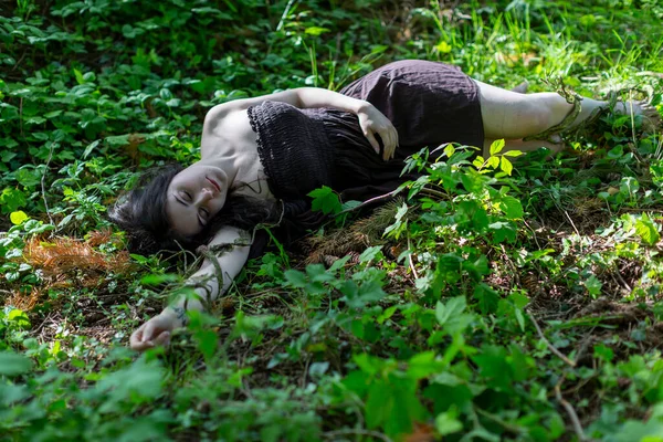 黑发女孩躺在常春藤的草地上 身无分文的棕色连衣裙 高质量的照片 — 图库照片