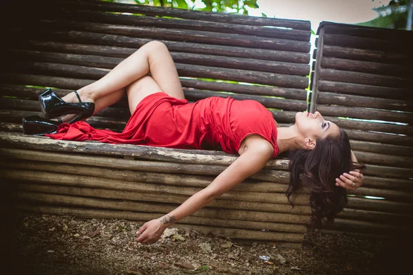 Menina Bonita Com Vestido Vermelho Longo Deitado Banco Foto Alta — Fotografia de Stock