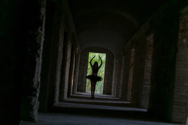 girl with tutu dances in the dark corridor. High quality photo
