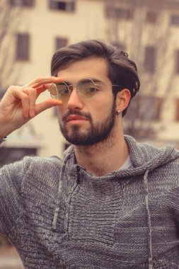 Sarı gözlüklü yakışıklı, koyu renk saçlı bir İtalyan portresi. Yüksek kalite fotoğraf