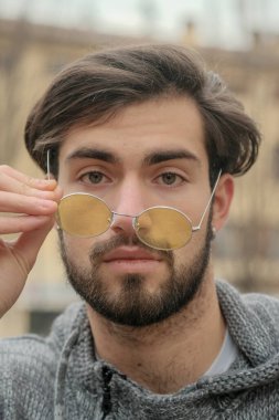 Sarı gözlüklü yakışıklı, koyu renk saçlı bir İtalyan portresi. Yüksek kalite fotoğraf