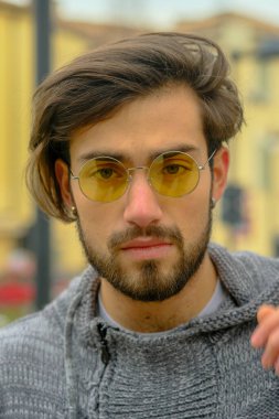 Sarı gözlüklü yakışıklı, koyu renk saçlı bir İtalyan portresi. Yüksek kalite fotoğraf