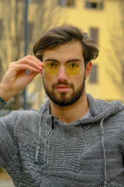 Sarı gözlüklü yakışıklı, koyu renk saçlı bir İtalyan portresi. Yüksek kalite fotoğraf