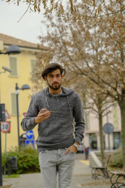 Uzun tişörtlü yakışıklı siyah saçlı çocuk geziniyor. Yüksek kalite fotoğraf