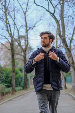 Kışlık ceketli yakışıklı siyah saçlı çocuk yürüyor. Yüksek kalite fotoğraf