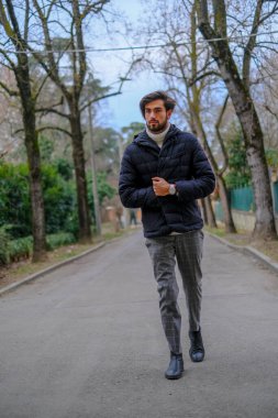 Kışlık ceketli yakışıklı siyah saçlı çocuk yürüyor. Yüksek kalite fotoğraf