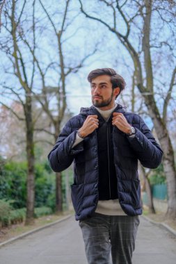 Kışlık ceketli yakışıklı siyah saçlı çocuk yürüyor. Yüksek kalite fotoğraf