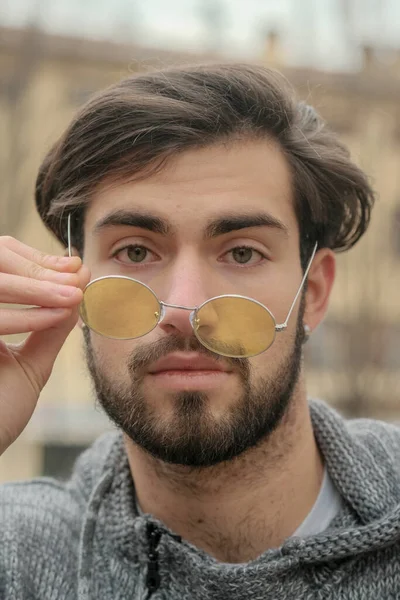 Sarı gözlüklü yakışıklı, koyu renk saçlı bir İtalyan portresi. Yüksek kalite fotoğraf