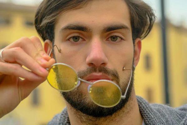 Sarı gözlüklü yakışıklı, koyu renk saçlı bir İtalyan portresi. Yüksek kalite fotoğraf