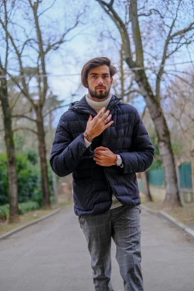 Kışlık ceketli yakışıklı siyah saçlı çocuk yürüyor. Yüksek kalite fotoğraf