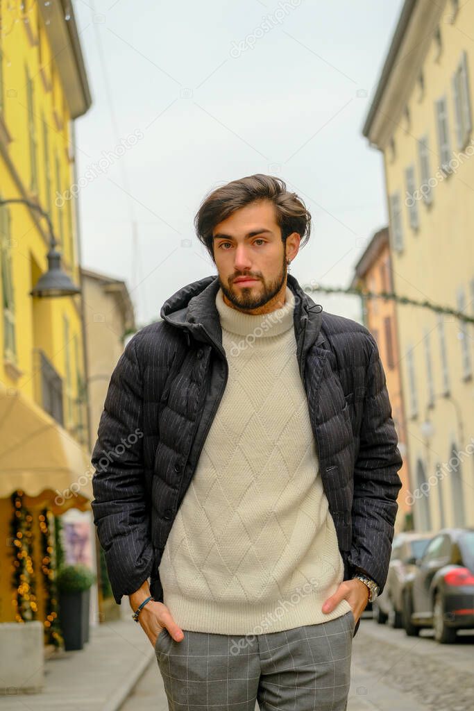 handsome Italian dark-haired boy with winter jacket walking. High quality photo