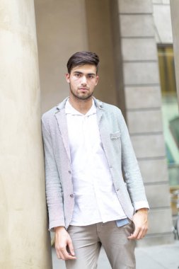 handsome Italian dark-haired guy with elegant jacket in the city center. High quality photo