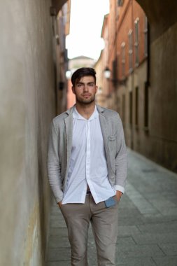 handsome Italian dark-haired guy with elegant jacket in the city center. High quality photo