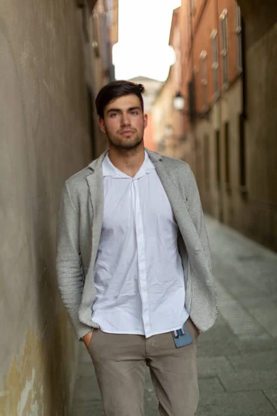 handsome Italian dark-haired guy with elegant jacket in the city center. High quality photo