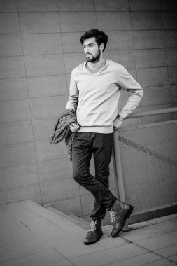 Uzun bir binanın çatısındaki yakışıklı, siyah saçlı adam. Yüksek kalite fotoğraf