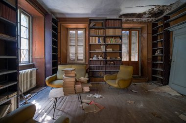 Büyük terk edilmiş evde eski kitap ve dergilerle dolu bir kütüphane. Yüksek kalite fotoğraf