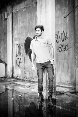 Dejenere olmuş terk edilmiş fabrikadaki yakışıklı siyah saçlı İtalyan adam. Yüksek kalite fotoğraf