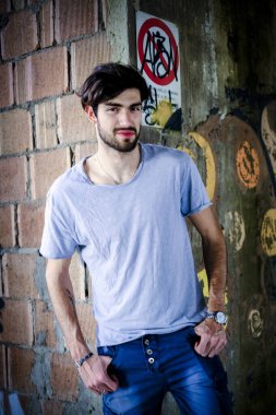 Dejenere olmuş terk edilmiş fabrikadaki yakışıklı siyah saçlı İtalyan adam. Yüksek kalite fotoğraf