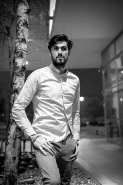 Beyaz gömlekli yakışıklı, koyu renk saçlı adam. Yüksek kalite fotoğraf