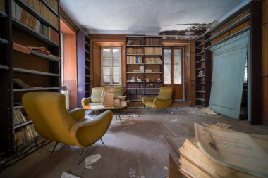 Büyük terk edilmiş evde eski kitap ve dergilerle dolu bir kütüphane. Yüksek kalite fotoğraf