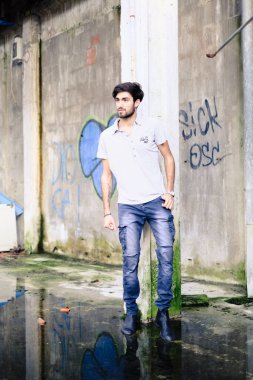 Dejenere olmuş terk edilmiş fabrikadaki yakışıklı siyah saçlı İtalyan adam. Yüksek kalite fotoğraf