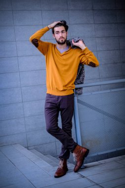 Uzun bir binanın çatısındaki yakışıklı, siyah saçlı adam. Yüksek kalite fotoğraf