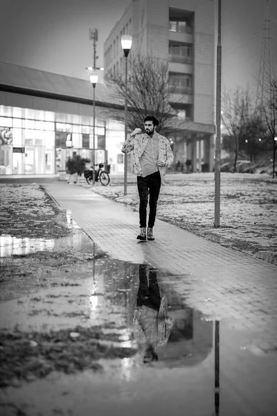handsome dark-haired italian guy walk in snowy winter park at evening. High quality photo