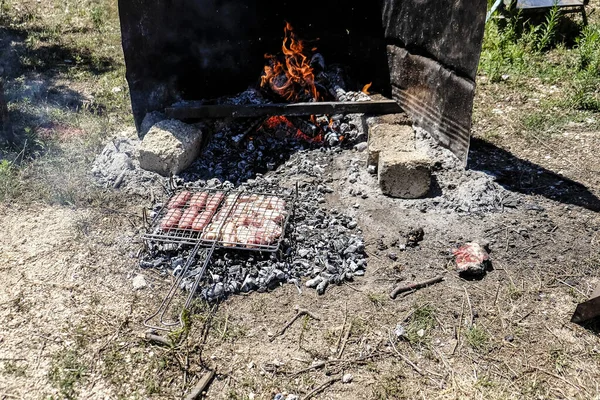 grilled meat cooked on the fire with sausages and chops and skewers. High quality photo