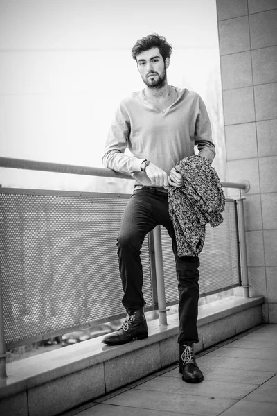 Uzun bir binanın çatısındaki yakışıklı, siyah saçlı adam. Yüksek kalite fotoğraf