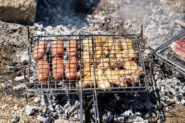 grilled meat cooked on the fire with sausages and chops and skewers. High quality photo