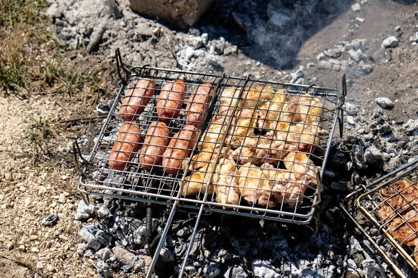 grilled meat cooked on the fire with sausages and chops and skewers. High quality photo