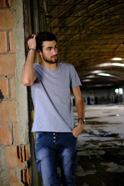 Güzel, siyah saçlı İtalyan çocuk inşaat halindeki fabrikada yürüyor. Yüksek kalite fotoğraf