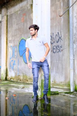 Dejenere olmuş terk edilmiş fabrikadaki yakışıklı siyah saçlı İtalyan adam. Yüksek kalite fotoğraf