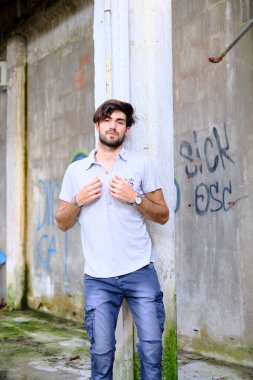 Dejenere olmuş terk edilmiş fabrikadaki yakışıklı siyah saçlı İtalyan adam. Yüksek kalite fotoğraf