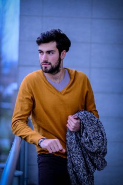 Uzun bir binanın çatısındaki yakışıklı, siyah saçlı adam. Yüksek kalite fotoğraf