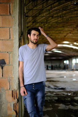 Güzel, siyah saçlı İtalyan çocuk inşaat halindeki fabrikada yürüyor. Yüksek kalite fotoğraf