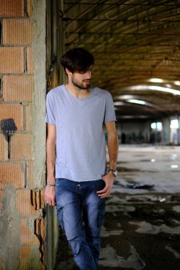 Güzel, siyah saçlı İtalyan çocuk inşaat halindeki fabrikada yürüyor. Yüksek kalite fotoğraf