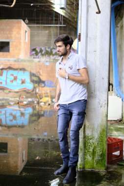 Dejenere olmuş terk edilmiş fabrikadaki yakışıklı siyah saçlı İtalyan adam. Yüksek kalite fotoğraf