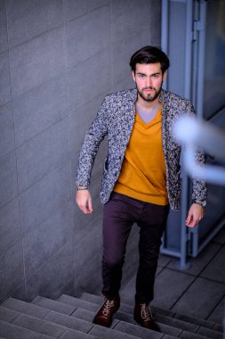 Uzun bir binanın çatısındaki yakışıklı, siyah saçlı adam. Yüksek kalite fotoğraf