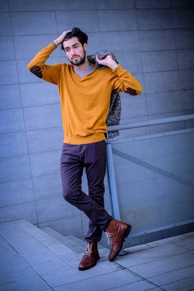 Uzun bir binanın çatısındaki yakışıklı, siyah saçlı adam. Yüksek kalite fotoğraf