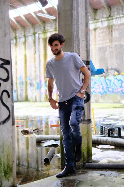 Dejenere olmuş terk edilmiş fabrikadaki yakışıklı siyah saçlı İtalyan adam. Yüksek kalite fotoğraf