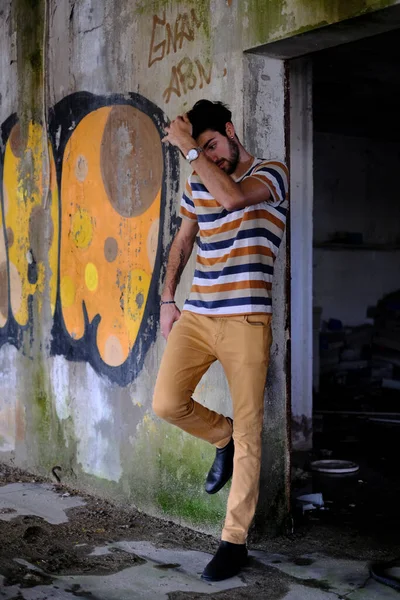 Dejenere olmuş terk edilmiş fabrikadaki yakışıklı siyah saçlı İtalyan adam. Yüksek kalite fotoğraf