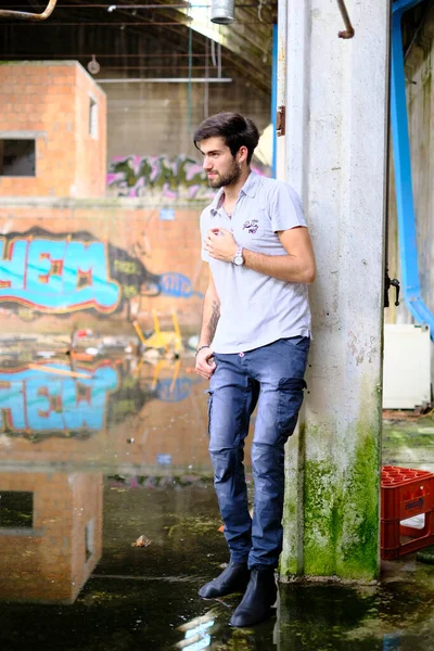 Dejenere olmuş terk edilmiş fabrikadaki yakışıklı siyah saçlı İtalyan adam. Yüksek kalite fotoğraf