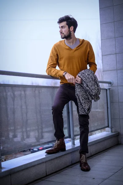 Uzun bir binanın çatısındaki yakışıklı, siyah saçlı adam. Yüksek kalite fotoğraf