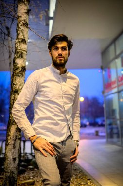 Yakışıklı, siyah saçlı İtalyan çocuk akşam şehir merkezinde yürüyor. Yüksek kalite fotoğraf