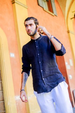 Ortadaki yakışıklı, siyah saçlı adam telefonu kullanıyor. Yüksek kalite fotoğraf